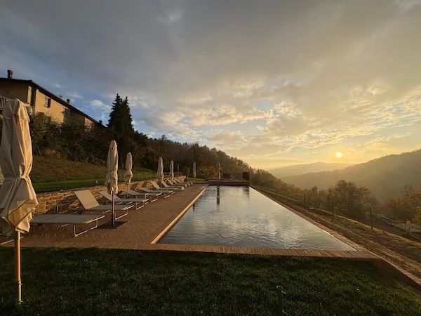 Golden sunset over the infinity pool at Borgo Isolabella in Loazzolo, Piemonte — VEDA Ayurvedic Wellness retreat setting